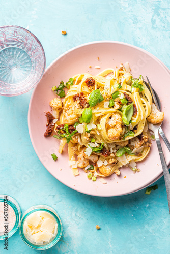 Tagliatelle pasta dish with cauliflower, sun dried tomatoes, basil, chiev, walnuts and parmesan cheese