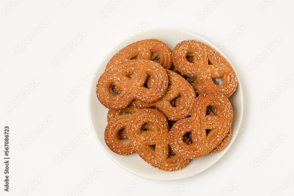Plate with shaped rye cookies or pretzels  with crystal sugar isolated on white background top view