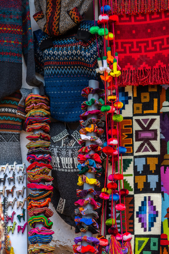 colorful sweaters made of alpaca wool are on sale at cusco store, peru © jon_chica