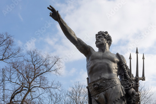 Neptune statue against the background of blue sky and clouds