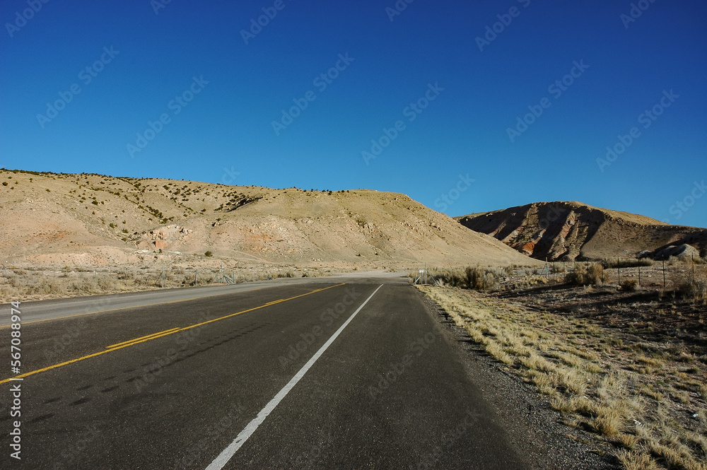 End of Paved Highway Leading into Dirt Road and the Desert Mountains End of Paved Highway Leading into Dirt Road and the Desert Mountains
