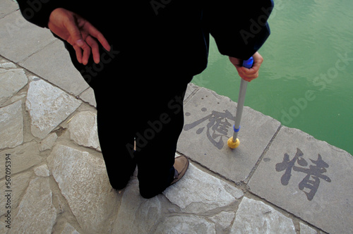 A man practices the art of Chinese calligraphy in Beijing People's Park. photo