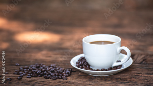 Banner of black drip coffee in ceramic cup on old wood table with coffee bean. Barista serve cup of hot black coffee on old wooden table cafe shop in garden with coffee bean.
