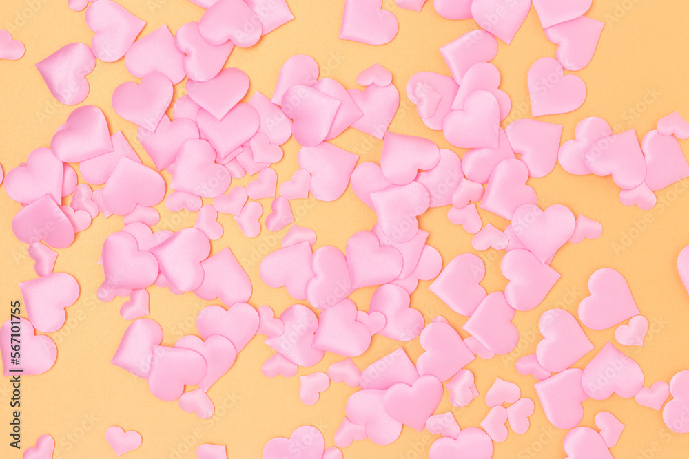 Texture made of textile pink confetti in a heart shape on a gold colored background. Holidays creative composition. Texture made of textile pink confetti in a heart shape on a gold colored background. Holidays creative composition.