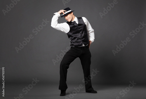Confident young man dancing in gangster style suite.