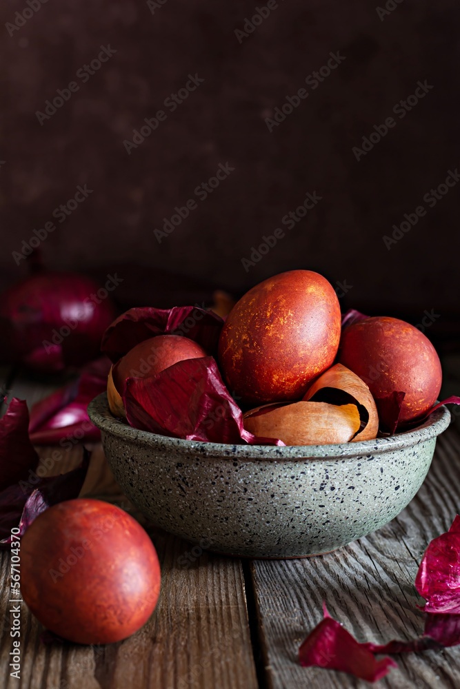 Boiled eggs dyed with onion peel in a bowl on a wooden background. Traditional Easter concept. Natural (ecological) dye for Easter eggs. Boiled eggs dyed with onion peel in a bowl on a wooden background. Traditional Easter concept. Natural (ecological) dye for Easter eggs.