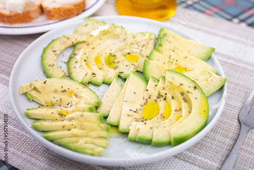 Fototapeta Naklejka Na Ścianę i Meble -  ripe avocado pulp cut into pieces sprinkled with lemon juice on a plate