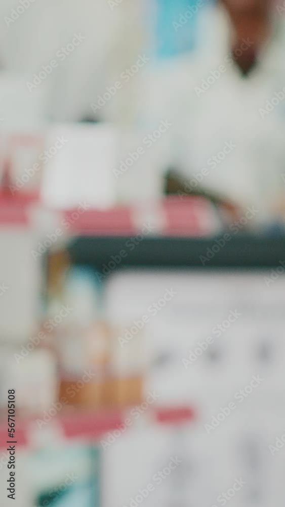 Vertical video: African american client looking at drugs on shelves, buying medicaments and healthcare products from drugstore. Young customer taking pills or vitamins from racks. Handheld shot. Vertical video: African american client looking at drugs on shelves, buying medicaments and healthcare products from drugstore. Young customer taking pills or vitamins from racks. Handheld shot.