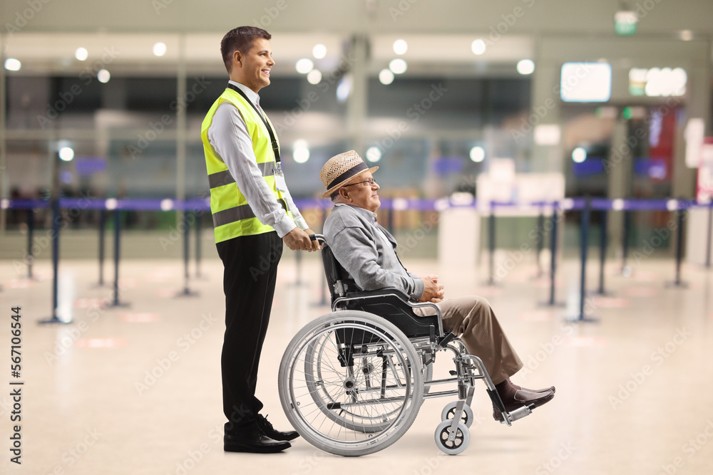 Male assitance worker with a senior passenger in a wheelchair at the airport
