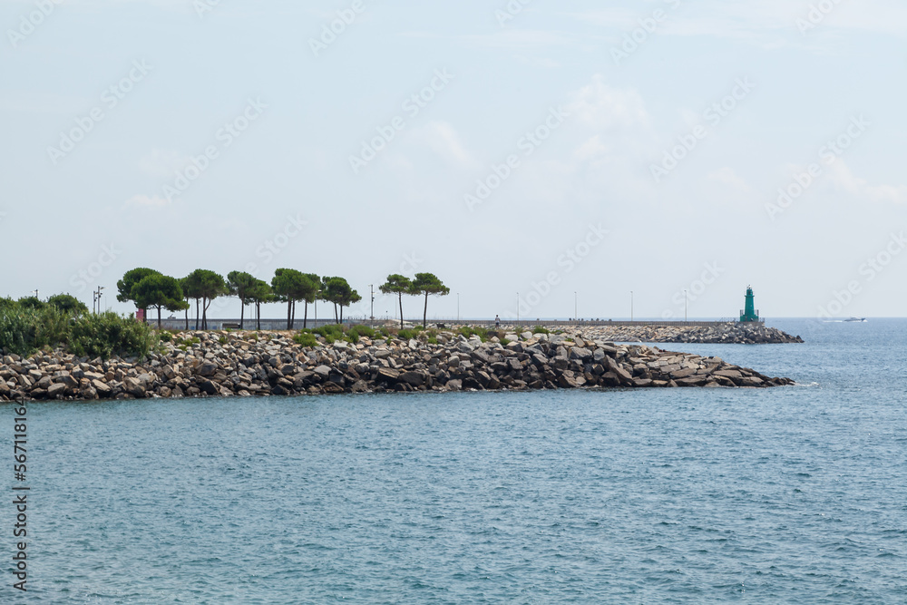 The lighthouse in the pier of Oneglia, the low district of the town of Imperia in west Riviera or Riviera of flowers in Liguria, Italy. The lighthouse in the pier of Oneglia, the low district of the town of Imperia in west Riviera or Riviera of flowers in Liguria, Italy.