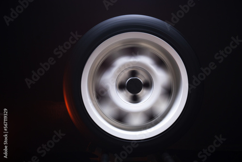 long exposure photography in motion spinning car titanium rims in blurry light 