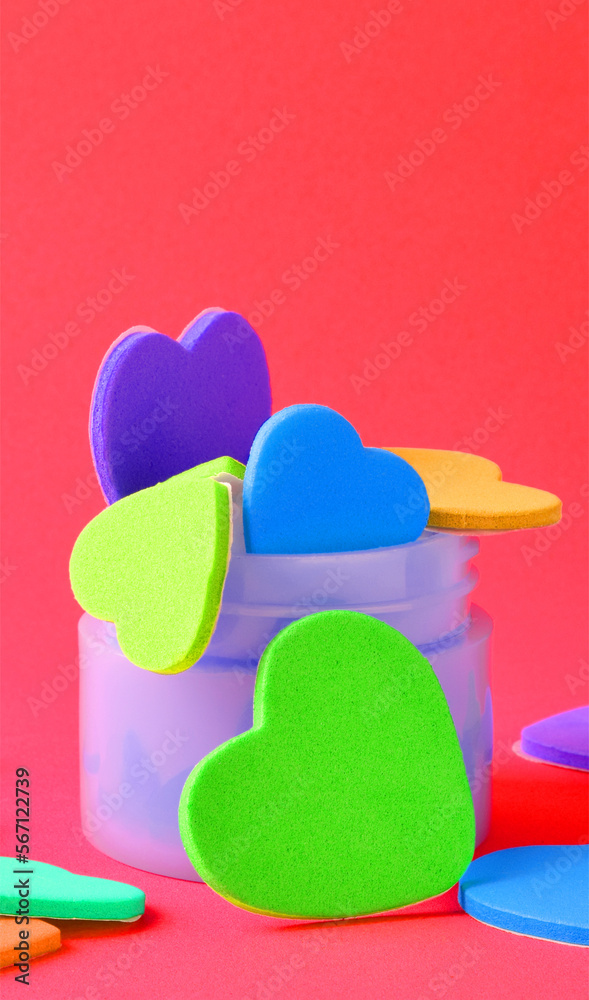 Valentine's day, love. Colored hearts inside a small container and scattered. Vertical shot and copy space. Valentine's day, love. Colored hearts inside a small container and scattered. Vertical shot and copy space.