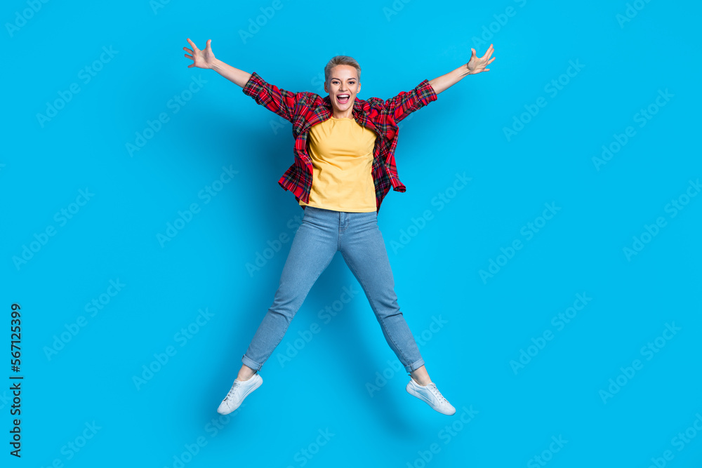 Full body size cadre of young overjoyed jumping carefree positive blonde short hair girl star symbol raise hands isolated on blue color background