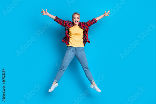 Full body size cadre of young overjoyed jumping carefree positive blonde short hair girl star symbol raise hands isolated on blue color background