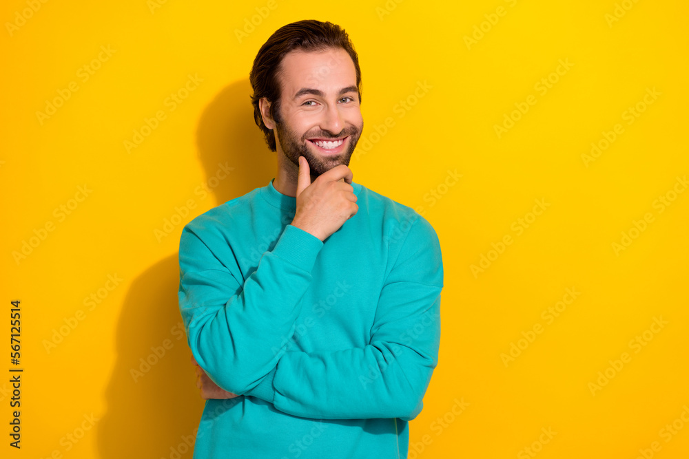 Photo of young funny smiling brutal handsome man brunet hair bristle beard touch chin minded looking you posing isolated on yellow color background Photo of young funny smiling brutal handsome man brunet hair bristle beard touch chin minded looking you posing isolated on yellow color background