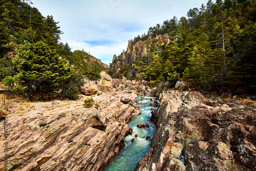 turquoise river of water with sulfur surrounded by forest and cloudy sky in basaseachi chihuahua, sierra tarahumara photo
