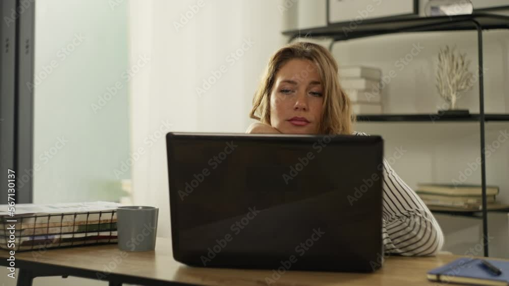 Tired woman working from home office. The freelancer strained her eyes while working at the computer. The girl propped her chin with her hand and falls asleep at work at home. High quality 4k footage