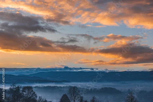 Obraz misty sunrise with orange clouds