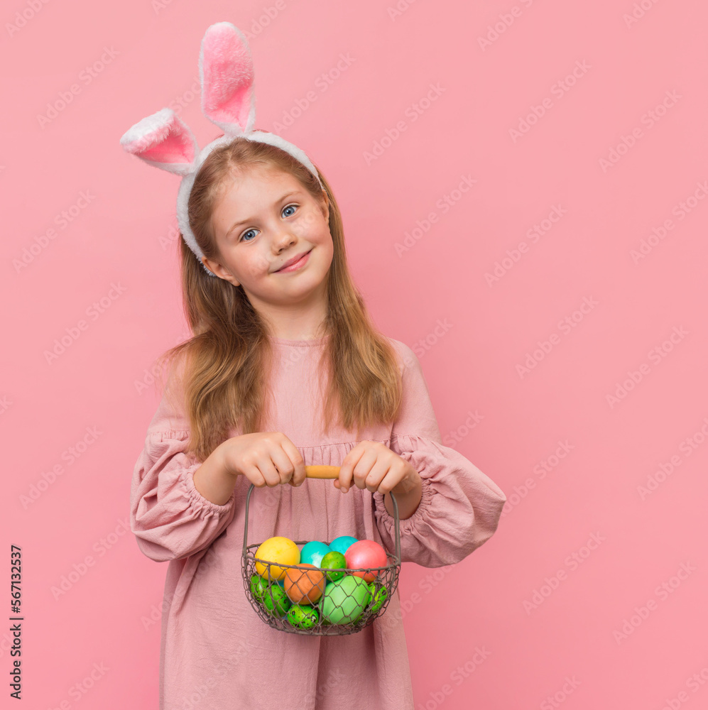Little girl with rabbit ears and basket with easter eggs on pink background. Little girl with rabbit ears and basket with easter eggs on pink background.