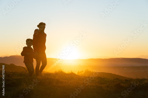 Mother and son silhouetted at sunset when walking © JoseLuis