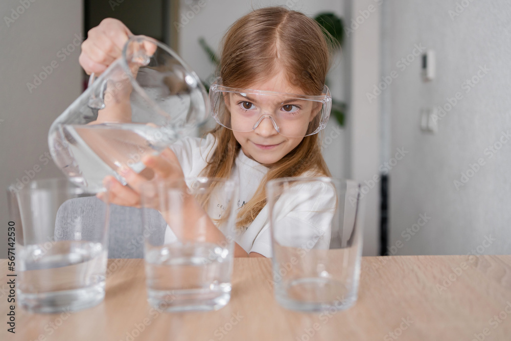 Kid making chemical experiments or tests home, improving knowledge, studying in playful manner, homeschooling concept. Kid making chemical experiments or tests home, improving knowledge, studying in playful manner, homeschooling concept.