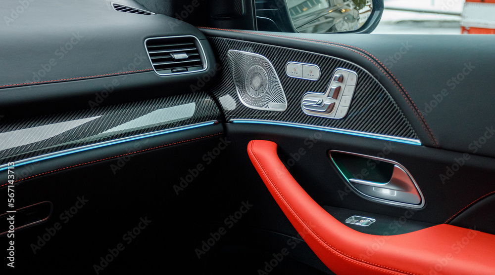door of an expensive car with red-black leather and ambient lighting with a premium audio system
