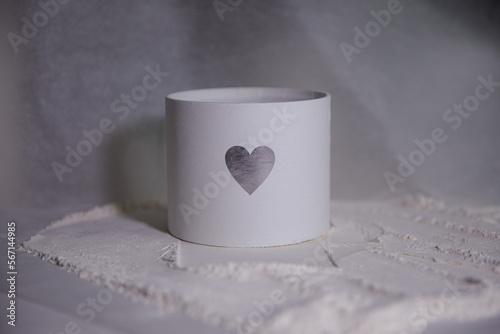 Valentine’s Day. Silver heart on white box. Festive round box. Minimalist print gift box. Texture picture