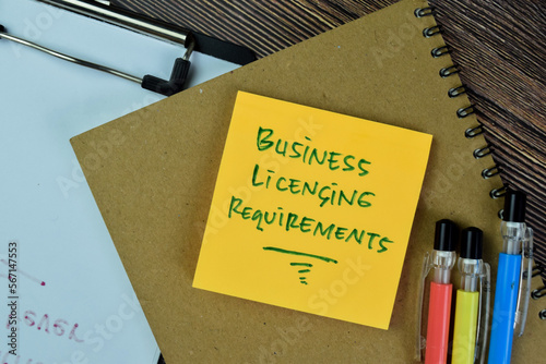 Concept of Business Licensing Requirements write on sticky notes isolated on Wooden Table.