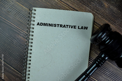 Concept of Administrative Law write on a book with gavel isolated on Wooden Table.