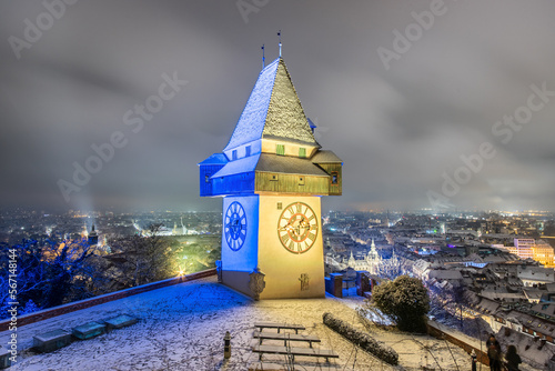 The famous landmark of Graz in Austria, the clock tower at the Schloßberg in winter illuminated with the colors of Ukraine