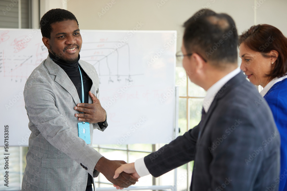 African businessman shaking hands to seal a deal with partner in the office African businessman shaking hands to seal a deal with partner in the office