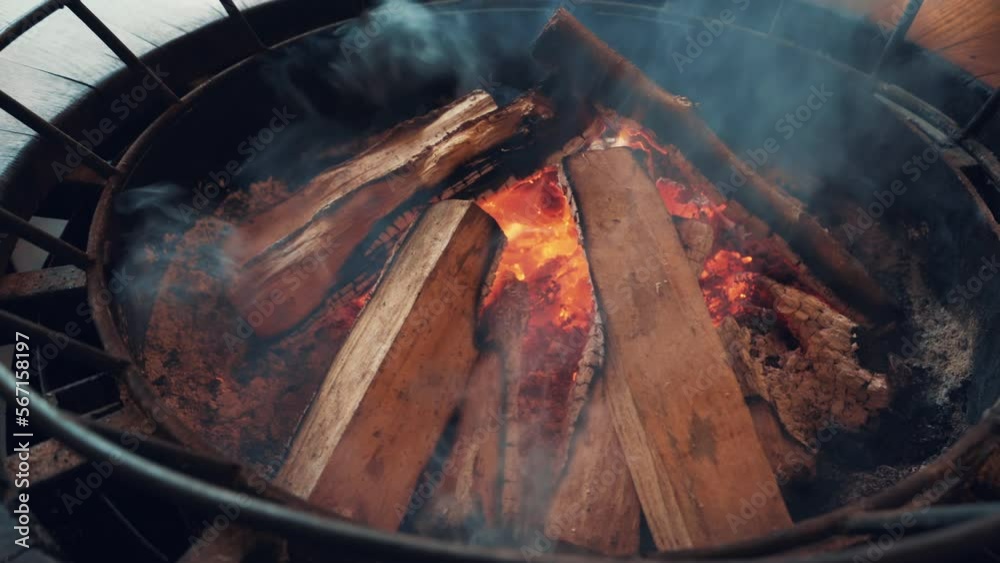 Burning firewood, fire and embers in stove for cooking or heating.