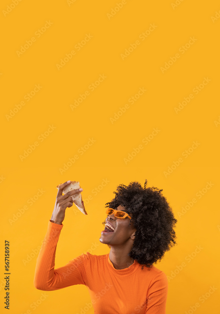 Happy African female with slice of pizza on isolated yellow background. Happy African female with slice of pizza on isolated yellow background.