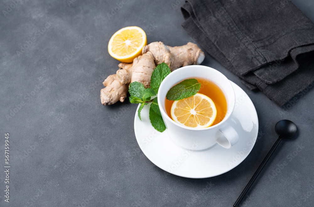 Cup of tea with lemon and mint on a dark background. The concept of a healthy drink for immunity with ginger and herbs. Diet and antioxidant tea. Cup of tea with lemon and mint on a dark background. The concept of a healthy drink for immunity with ginger and herbs. Diet and antioxidant tea.
