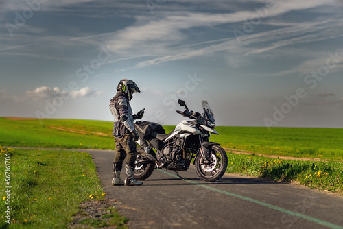 Fototapeta Naklejka Na Ścianę i Meble -  Landscape with motorcycle rider on the road near triumph motorcycle