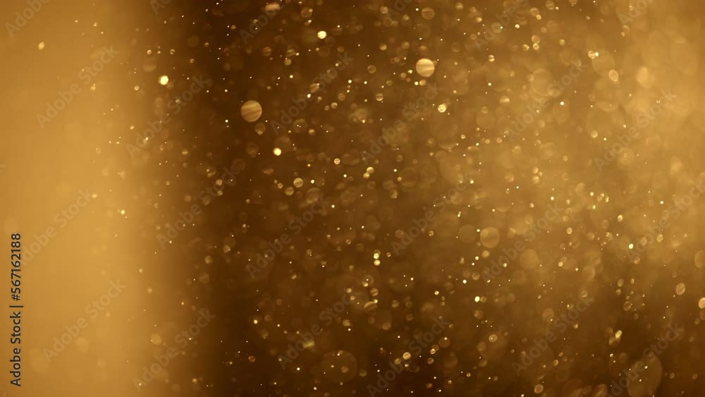 Shining golden particles abstract background. Gold dust particles fly in the air. Glimmering glowing gold bokeh background. Magical fairy background