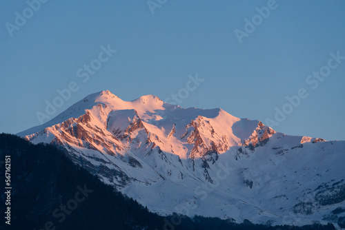 Caucasian snow-capped mountains. Snow-covered mountains in the sunset light close-up.