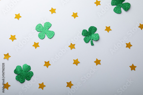 Green shamrocks and golden stars decorations with copy space on white background