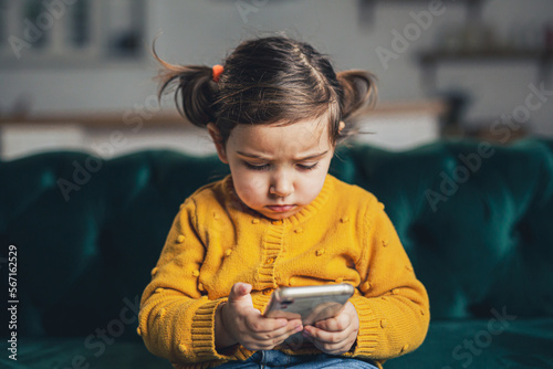 Kid using device.at home. Child playing video games or watching cartoon.