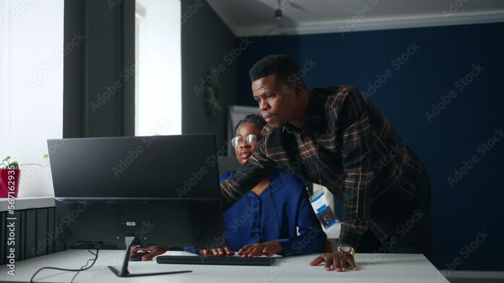 black supervisor controlling work of junior data analyst woman in office, coworkers communication