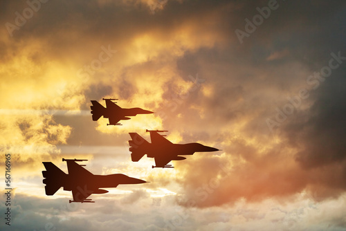 Air Force Day. Aircraft silhouettes on background of sunset. Combat flight of interceptors on a mission.