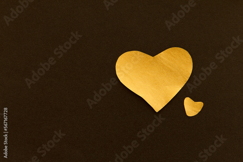 Golden sparkling heart on a black background  made of paper  romantic and festive symbol  background