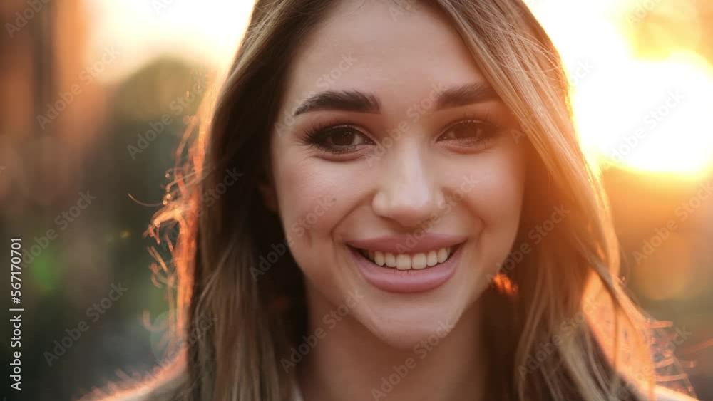 Close up view of charming woman looking to camera. Portrait of pretty girl standing at sunset light Close up view of charming woman looking to camera. Portrait of pretty girl standing at sunset light