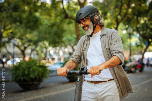 Cheerful mature man on electric scooter.