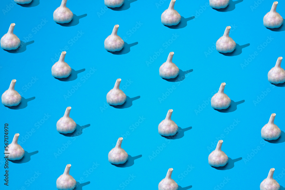 Garlic heads lay on blue table background Garlic heads lay on blue table background