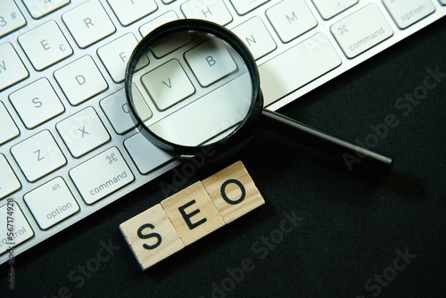 Magnifying glass and laptop keyboard. Seo.