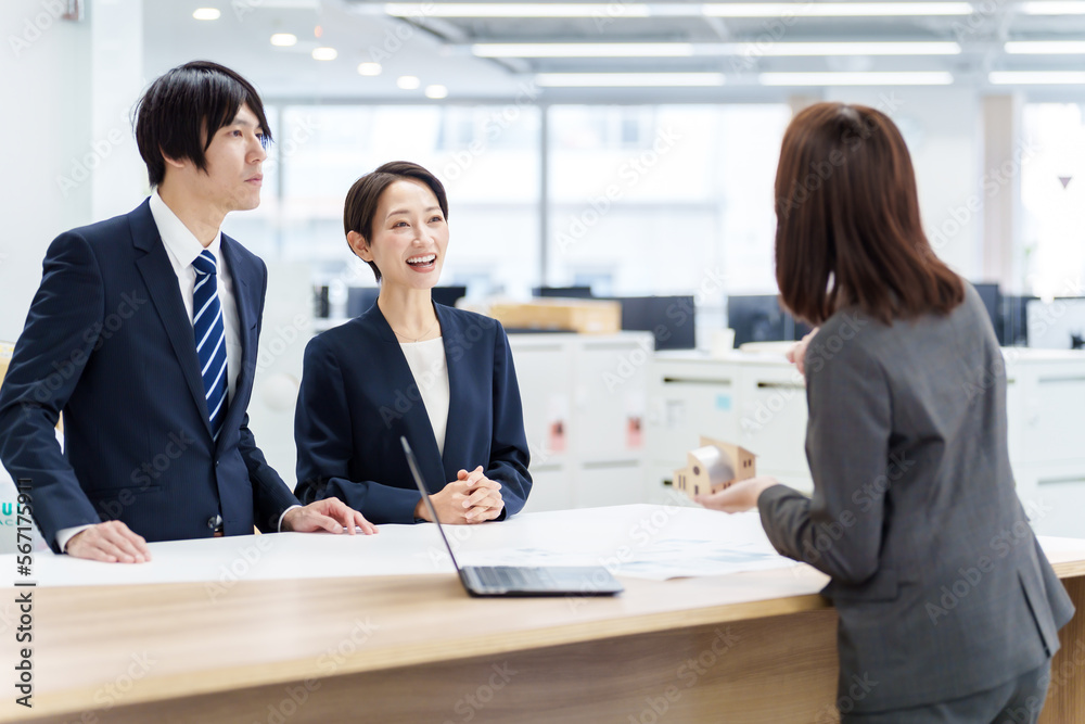 不動産の模型を使って打ち合わせをする人々 不動産の模型を使って打ち合わせをする人々