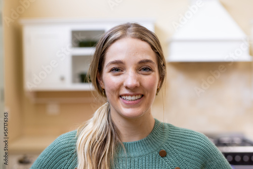 Portrait of smiling blonde caucasian woman in kitchen at home