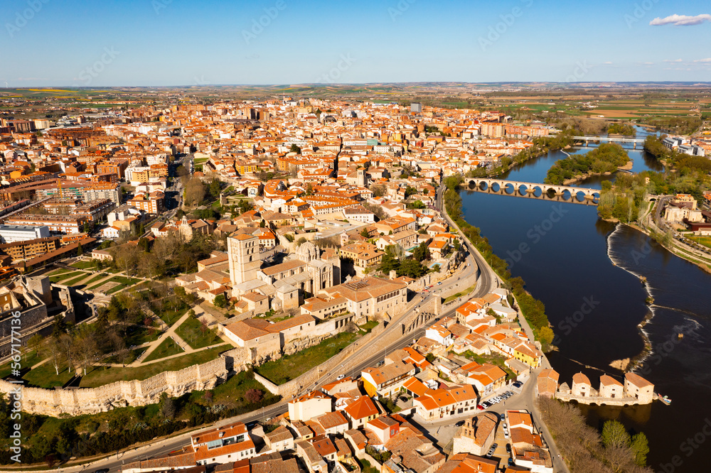 Scenic drone view of ancient walled Spanish city of Zamora on bank of Duero River overlooking Romanesque medieval cathedral on sunny spring day