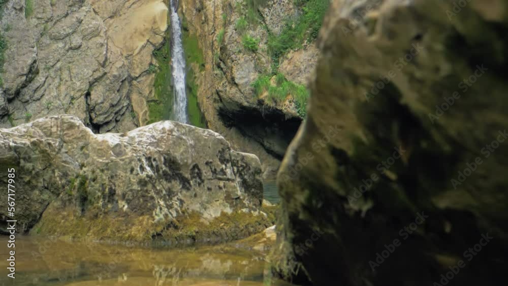 Spring waterfall among mountain rocks. In spring, snow melts intensively in the mountains, forming turbulent streams of clear water flowing into mountain valleys. Slow motion. Wildlife beauty concept Spring waterfall among mountain rocks. In spring, snow melts intensively in the mountains, forming turbulent streams of clear water flowing into mountain valleys. Slow motion. Wildlife beauty concept